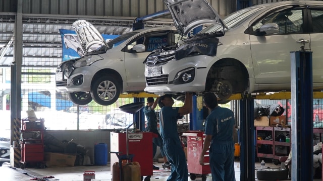 Teknisi melakukan servis mobil